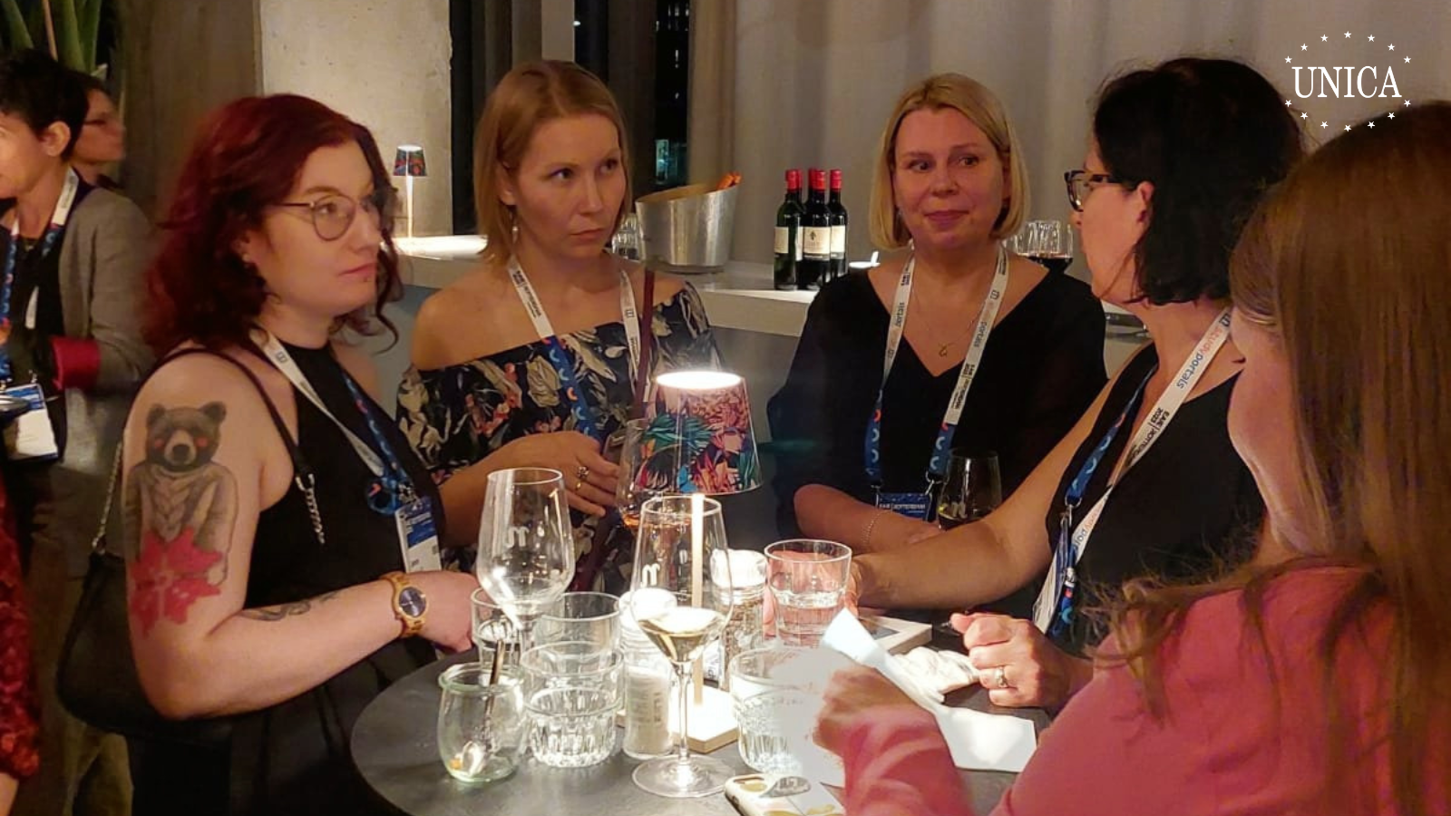 5 women socializing around a high table