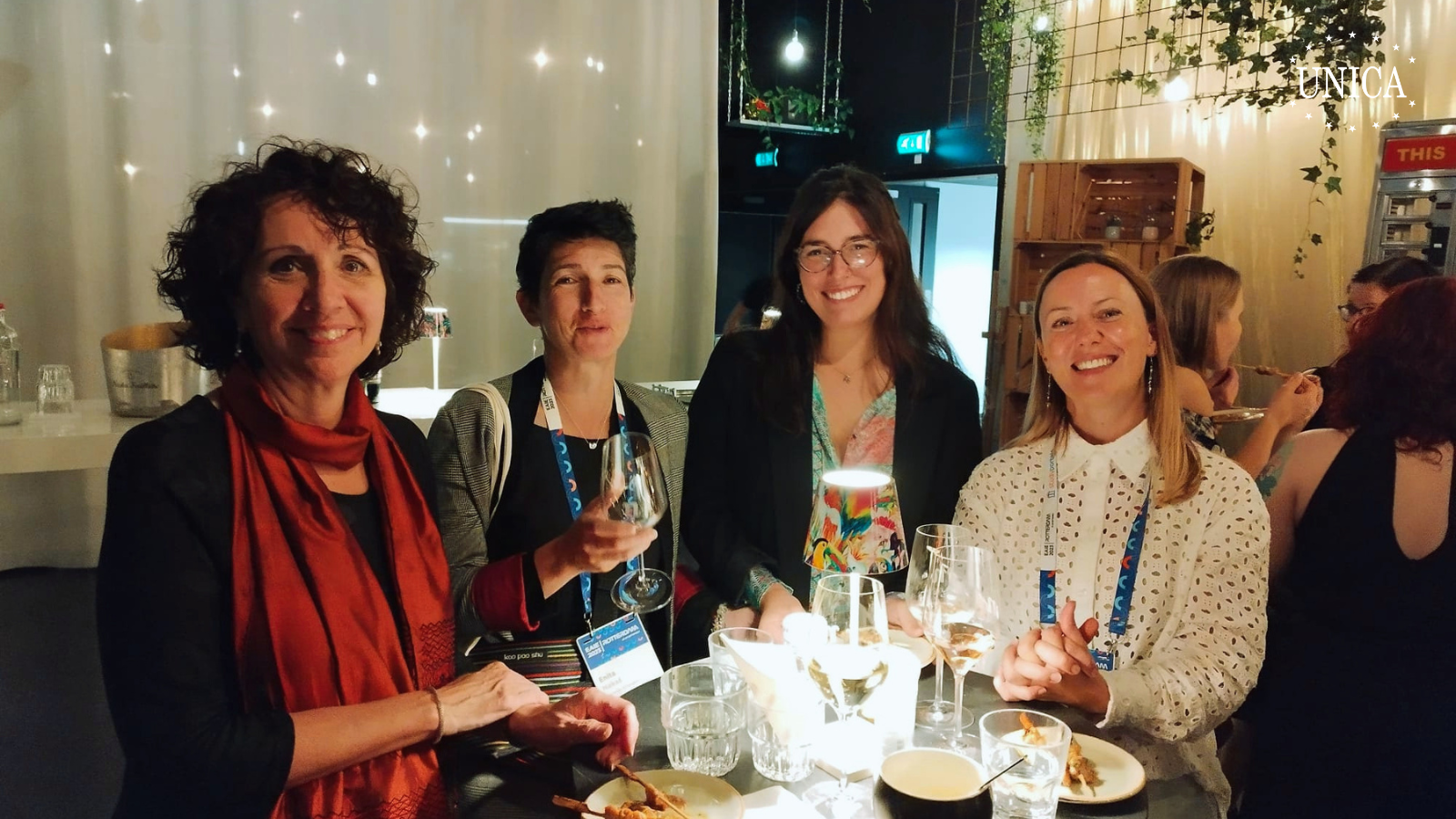 4 women posing for the picture around a high table